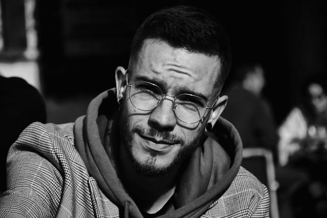Schwarz-weiß Foto von einem Mann mit fragendem Gesichtsausdruck und gerunzelter Stirn.