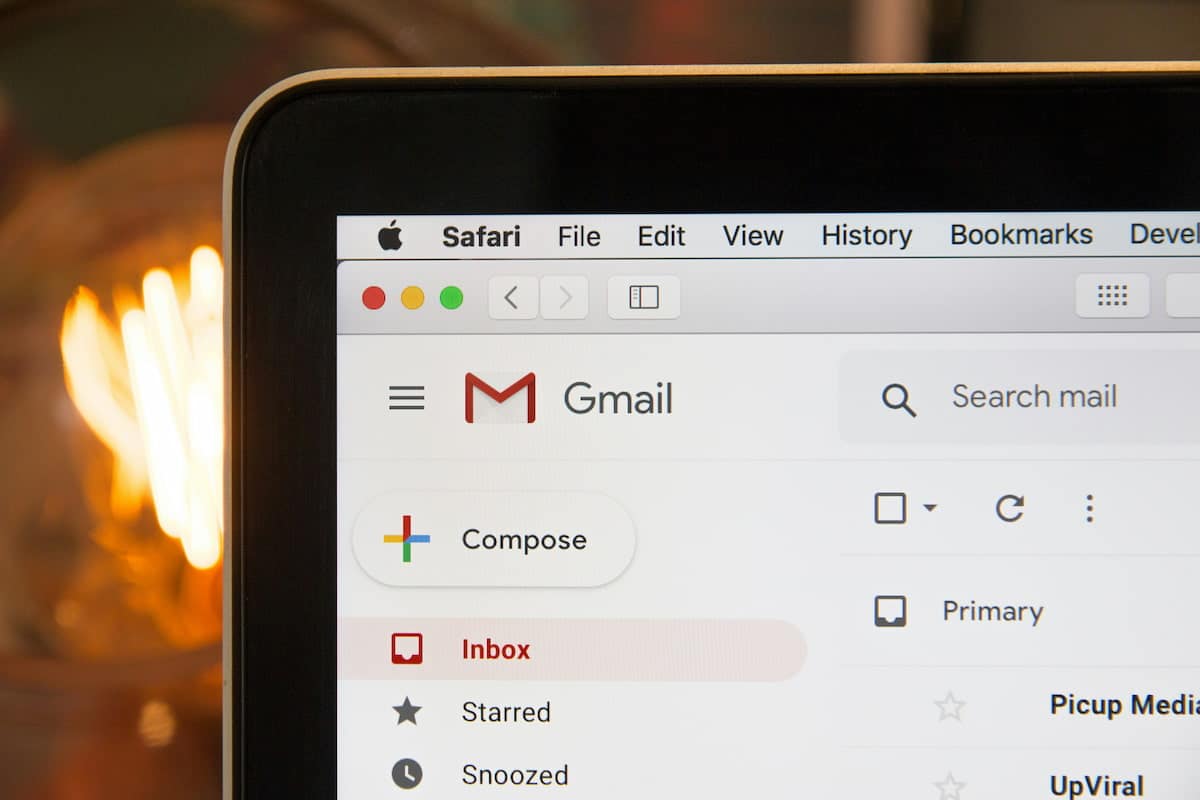 Ein E-Mail-Posteingang mit ungeöffneten neuen Mails auf einem Laptop vor einem Kaminfeuer.