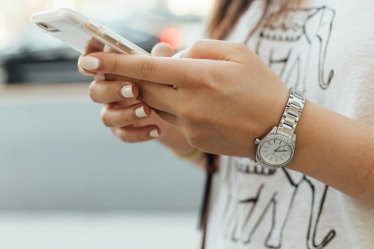 Eine Frau hält ein Smartphone in ihren Händen.