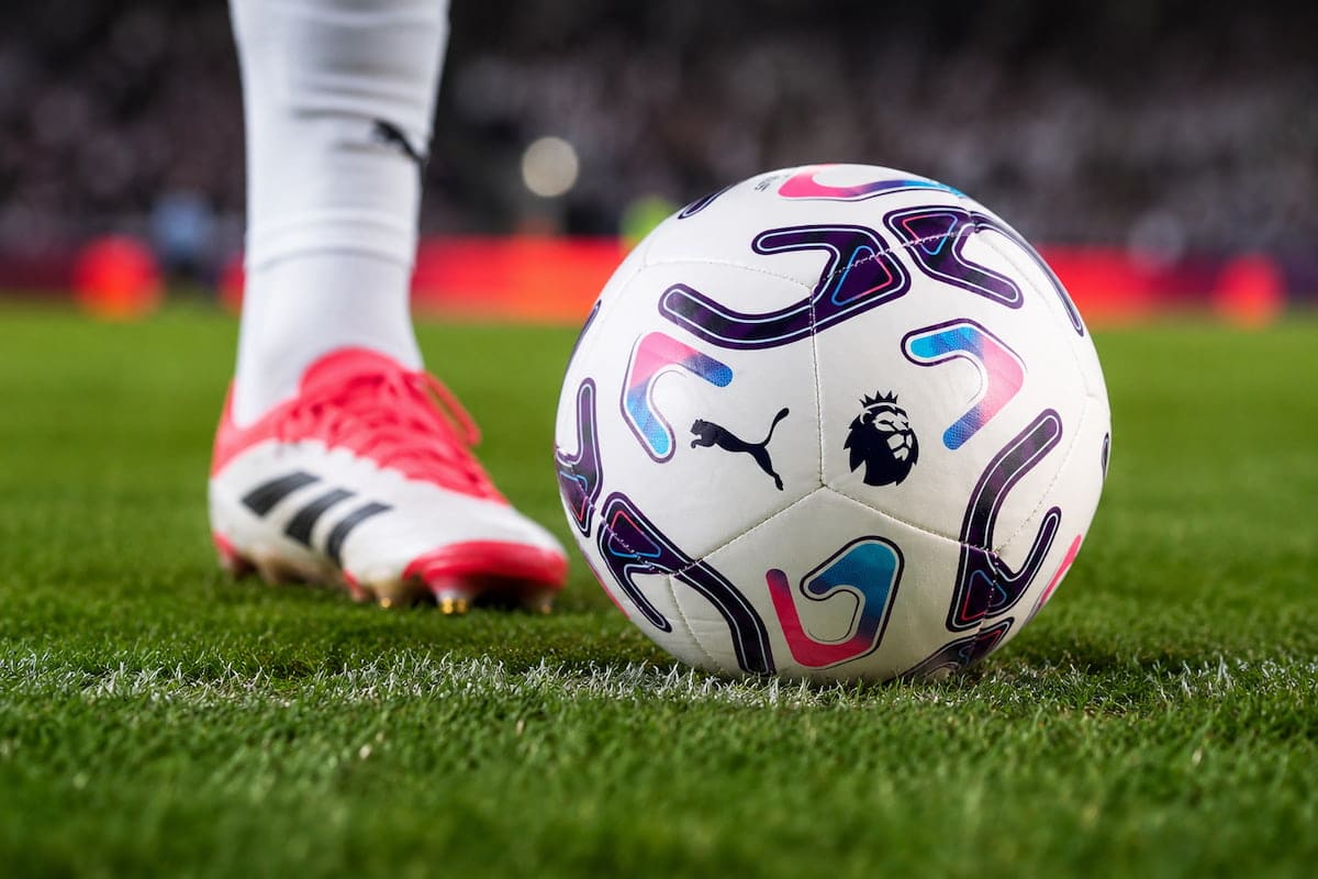Der neue Premier League 2026-27 Fußball liegt auf einem Spielfeld bei den Fußballschuhen eines Spielers.