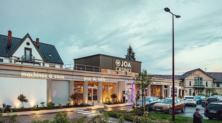 Exterior view of a JOA Casino building in France with signage for slot machines and table games
