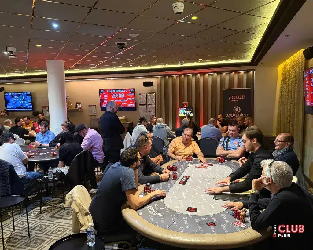Players at poker tables in Club Circus Paris during a tournament event.