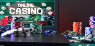 테이블에 온라인 카지노에 접속중이 노트북과 칩이 놓여있다.