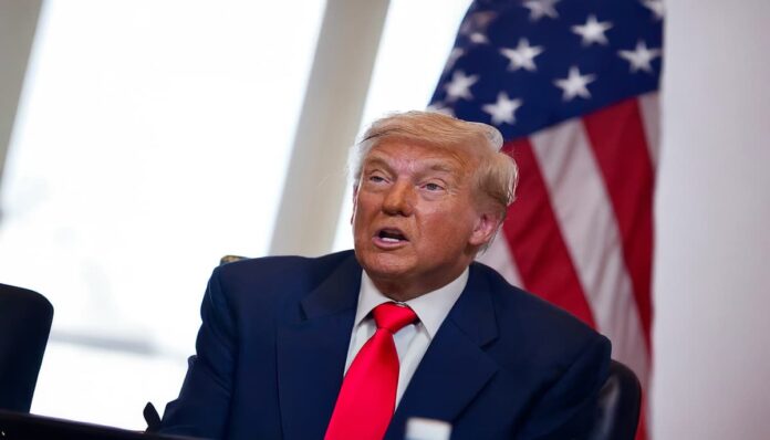 트럼프 도날드 트럼프가 미국 국기 앞에 앉아 있는 모습