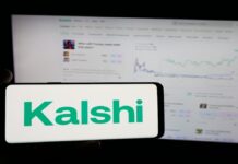 예측 시장 칼시, 불법 스포츠 베팅 논란… 베팅 플랫폼 이용자 경각심 필요 핸드폰에는 칼시 로고가 띄어져있고, 뒤에 보이는 모니터에서는 차트를 읽을 수 있다