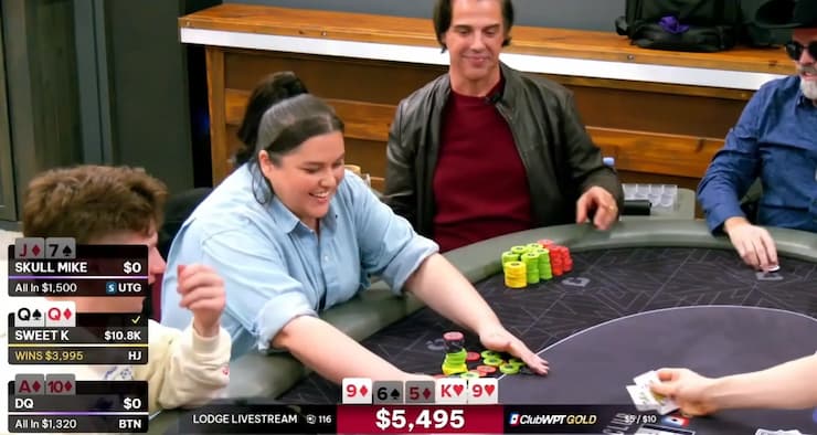 케일라가 테이블에 놓인 칩을 모으며 환하게 웃음 짓고 있다.