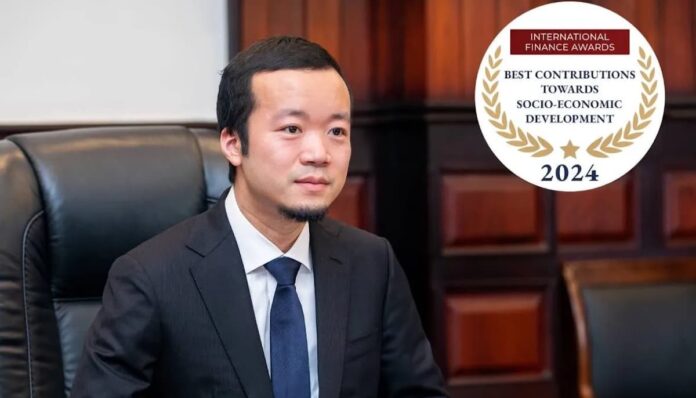 프린스 홀딩스 천즈 프린스 홀딩스 회장 천즈가 정장 차림으로 앉아있고 우측 상단에 국제 금융 어워즈 2024 수상 로고가 있다