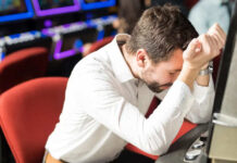 Consumentenbond: Casino’s gebruiken misleidende technieken man zit verslagen achter gokkast