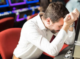 Consumentenbond: Casino’s gebruiken misleidende technieken man zit verslagen achter gokkast