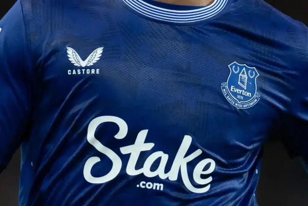 Close-up of an Everton football jersey featuring the Stake logo.