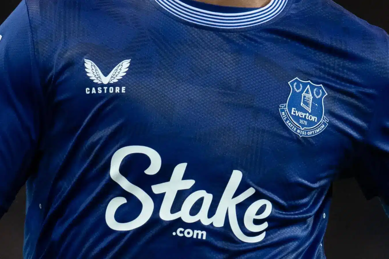 Close-up of an Everton football jersey featuring the Stake logo.