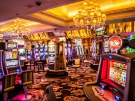 Färgglada spelautomater och blinkande lampor i ett casino med lyxiga mattor och taklampor.