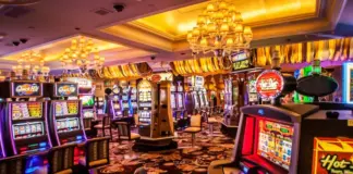 Färgglada spelautomater och blinkande lampor i ett casino med lyxiga mattor och taklampor.