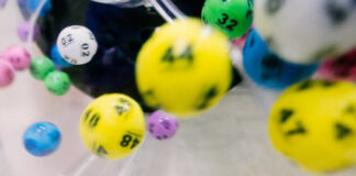 Färgglada lotteribollar med siffror snurrar i en lottodragningsmaskin