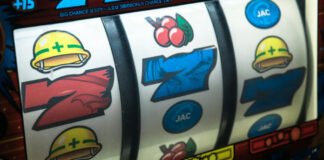 Närbild av spelautomat med hjul som visar symboler som hjälm, körsbär och siffror.