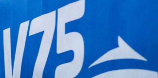 Vitt V75-tryck mot blå bakgrund, del av logotyp för travtävlingar.