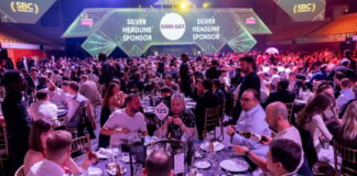 Prisutdelning på SBC Awards 2025 med välklädda gäster vid runda middagsbord i en upplyst arena.