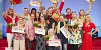 Grupp glada vinnare firar med blommor och stora checkar från Postkodlotteriet.