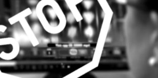 Person vid dator med slots på skärmen, överlagt STOP-tecken i vitt, suddig bakgrund.