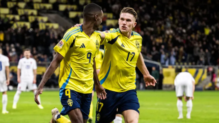 sverige-slovenien-vm-kval-2026 Två svenska fotbollsspelare firar mål i landslagets gula tröjor under en match på fullsatt arena.
