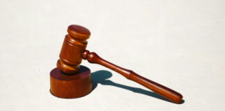 Trädomareklubba mot ljus bakgrund, symbol för rättssystemet och juridiska beslut.