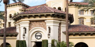 Elegant byggnad med tegeltak, palmträd och GVR-logotyp vid entrén till ett kasinohotell.