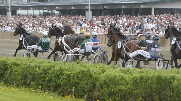 stora-problem-för-atg Travhästlopp med kuskar på sulkys inför stor publik på travbana.