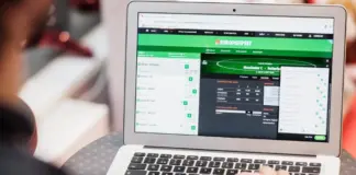 Person använder laptop för att lägga spel på Europatipset, sportsbetting-sajt är öppen på skärmen.