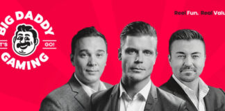 Tre personer i kostym framför röd bakgrund med Big Daddy Gaming-logotypen till vänster.
