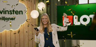 Leende kvinna firar vinst med konfetti framför Lotto-logotyp och skylten ”Drömvinsten”.