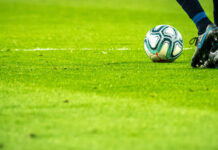 Kvalet till Allsvenskan klart: Norrköping möter Örgryte Fotbollsspelare i rörelse på grön plan med bollen nära fötterna.