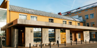 En gul byggnad vid en domstol/tingsrätt med entré och svart stolpar framför.