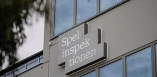 Spelinspektionens logotyp på byggnadsfasad med glasfönster i bakgrunden.