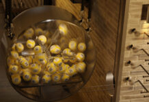 Fyra syskon från Skåne vinner två miljoner på Keno Lotterimaskin med gula numrerade bollar som snurrar i genomskinlig trumma.