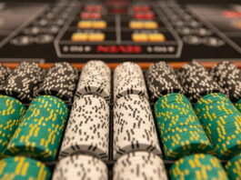 Närbild av staplade casinonmarker i olika färger på ett spelbord.