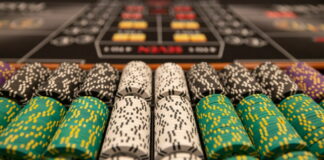 Närbild av staplade casinonmarker i olika färger på ett spelbord.