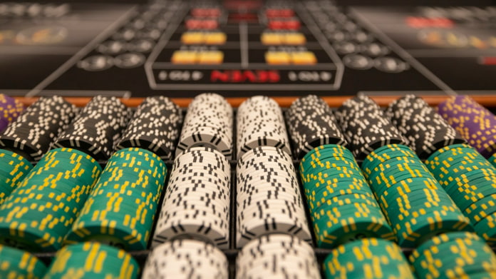 illegal-spelklubb-stängs Närbild av staplade casinonmarker i olika färger på ett spelbord.