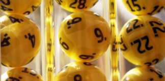 Kompisgäng från Stockholm vinner 2,3 miljoner på Eurojackpot Närbild på gula lotteribollar med svarta siffror i en dragmaskin