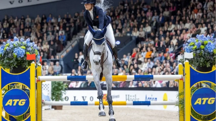 atg-sponsrar-svensk-hästsport Ryttare på häst hoppar hinder under tävling i fullsatt arena, med ATG-logotyper vid hindret.