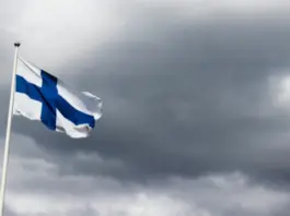 Gaming in Finland lanseras vid ICE 2026 Finlands flagga vajar i vinden mot en mörk och molnig himmel.