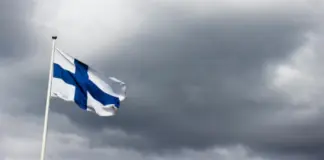 Gaming in Finland lanseras vid ICE 2026 Finlands flagga vajar i vinden mot en mörk och molnig himmel.