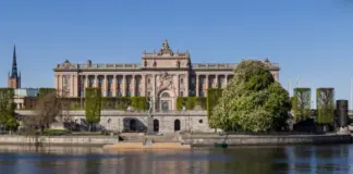 Regeringen beslutar om Spelinspektionens regleringsbrev för 2026 Riksdagshuset i Stockholm sett från vattnet en solig dag med grönska och klar himmel.