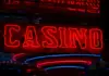 Onlinecasino 2026: Tillväxt och stramare reglering Röd neonskylt med texten ”Casino” lyser i mörk miljö med reflektioner.