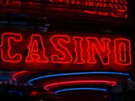 Onlinecasino 2026: Tillväxt och stramare reglering Röd neonskylt med texten ”Casino” lyser i mörk miljö med reflektioner.