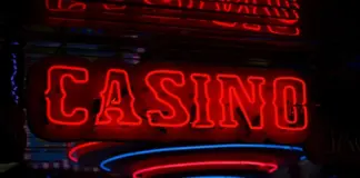 Onlinecasino 2026: Tillväxt och stramare reglering Röd neonskylt med texten ”Casino” lyser i mörk miljö med reflektioner.