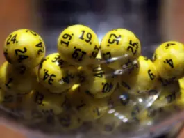 Spelare från Ystad vinner över 1,2 miljoner i Eurojackpot Gula lotteribollar med svarta siffror samlade i en transparent behållare inför dragning.