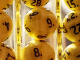 Man i 60-årsåldern vinner stort på Eurojackpot Gula lotteribollar med svarta siffror i genomskinliga rör, redo för dragning i Eurojackpot.