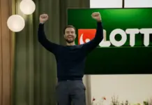 Man jublar med armarna i luften framför Lotto-skärm i studio hos Svenska Spel.