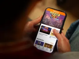 Spelberoende man vinner mot Betsson i hovrätten Person håller mobiltelefon med Betssons spelapp öppen