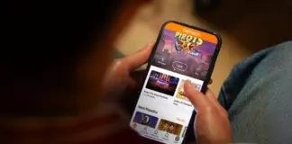 Spelberoende man vinner mot Betsson i hovrätten Person håller mobiltelefon med Betssons spelapp öppen